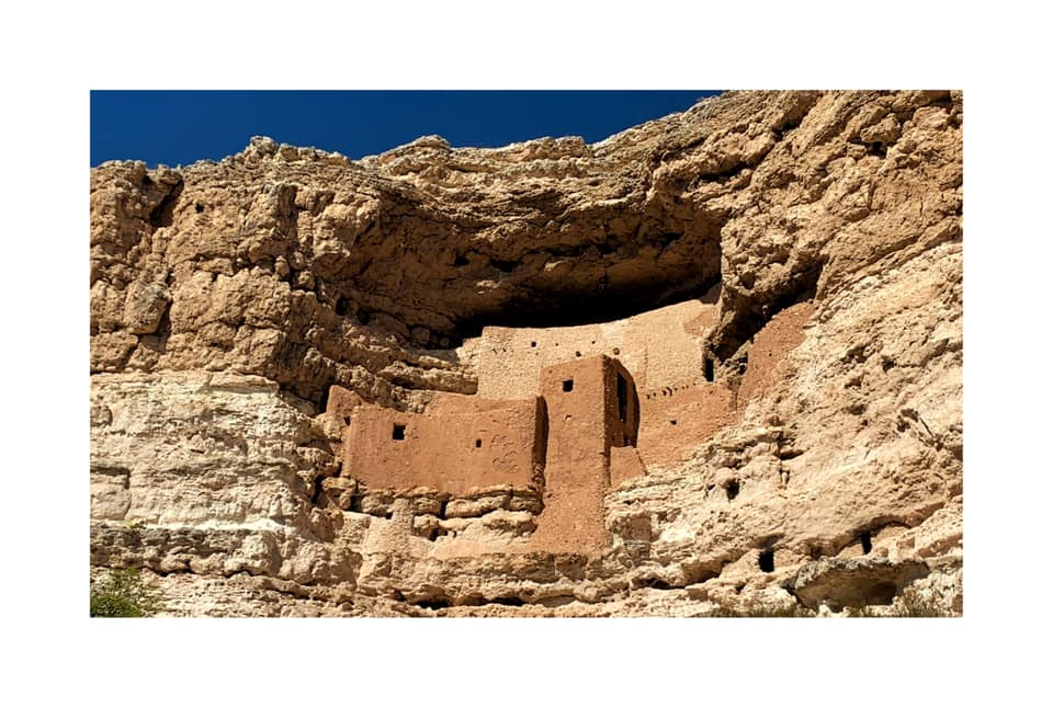View of the ancient cliff dwellings at Montezuma Castle National Monument in Arizona, showcasing well-preserved Native American architecture built into the limestone cliffs.
