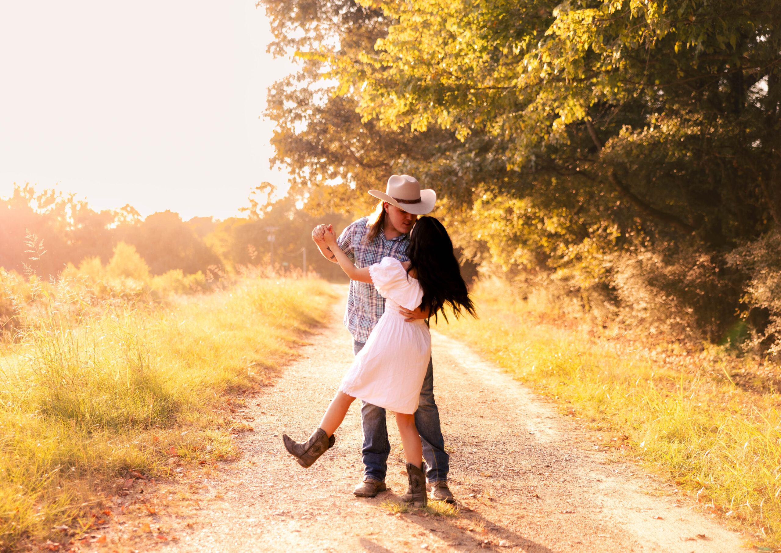Couple kissing on a golden-hour country road, illustrating how to plan an elopement with a romantic and intimate feel.